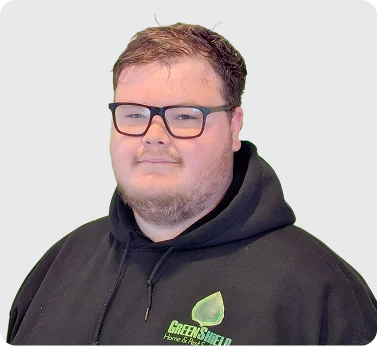 Man wearing dark green GreenShield Home & Pest Services hoodie and black rectangular glasses